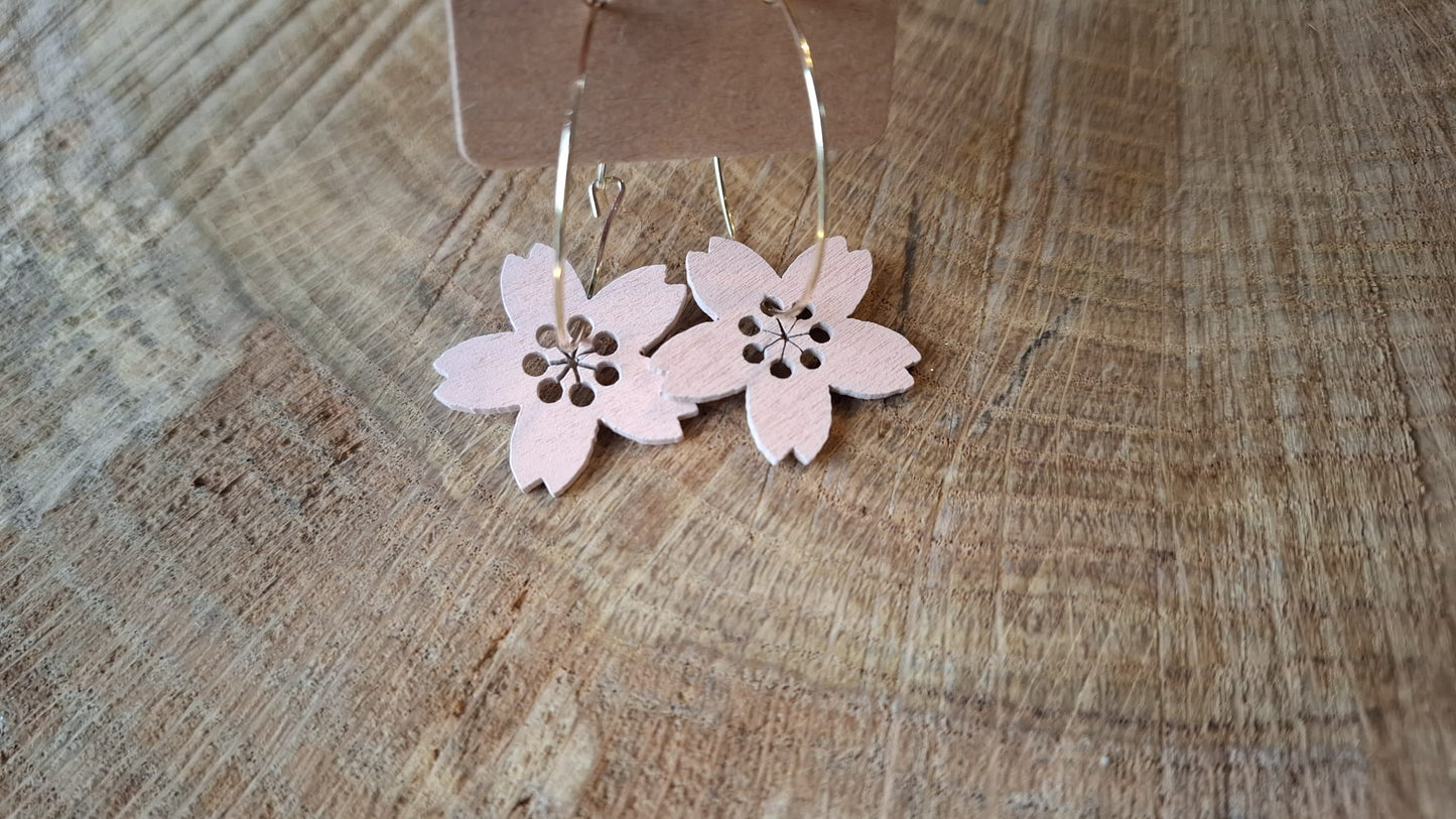 Goldene Creolen trifft auf rosa Blume